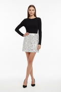 Model wearing white sequin grid mini skirt
